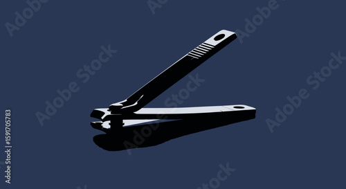 Close-up shot of a shiny, metallic nail clipper resting on a dark blue surface.