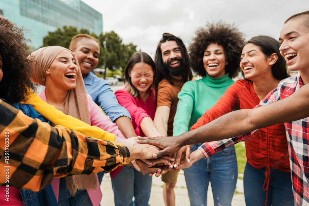 Obraz premium Young multiracial people having fun stacking hands outdoor - Diversity and joyful lifestyle concept - Soft focus on african hand