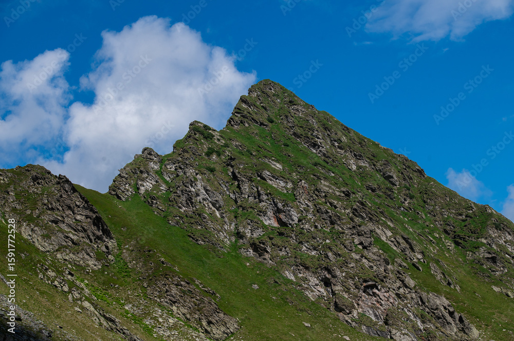 Fototapeta premium Steep rocky ridge under a clear sky in the Fagaras Mountains, Romania. Summer hiking scenery. 