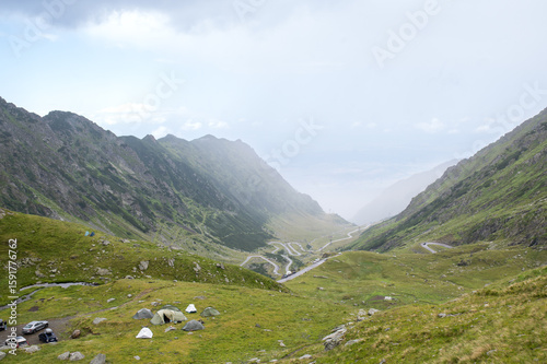 Panoramic view of the Făgăraș Mountains with a winding road disappearing into the mist. Transfăgărășan, Romania.
