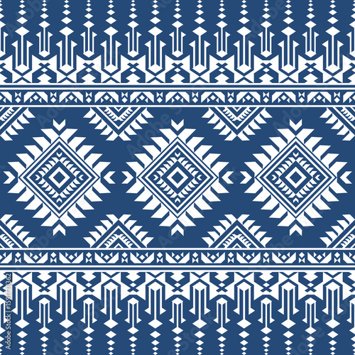 Seamless pattern featuring repeating geometric shapes and tribal inspired designs in white against a dark blue backdrop