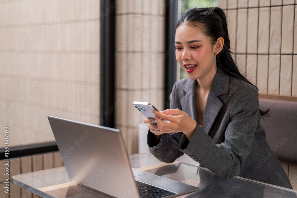 woman is sitting at a table with a laptop and a cell phone woman is sitting at a table with a laptop and a cell phone