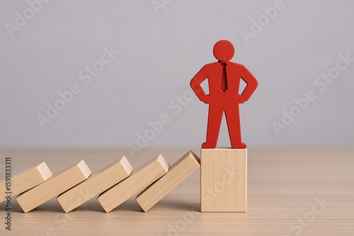 Red figure standing confidently on top of a block with falling dominoes in the background.