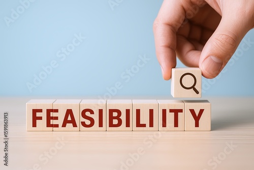 Hand placing wooden block with search icon above spelling feasibility in wooden tiles.