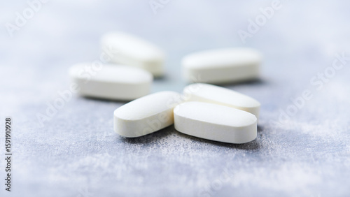 Amino acids tablets on wooden background. Soft focus. Close up	