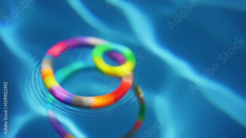 Colorful Pool Rings Dance on Rippled Water