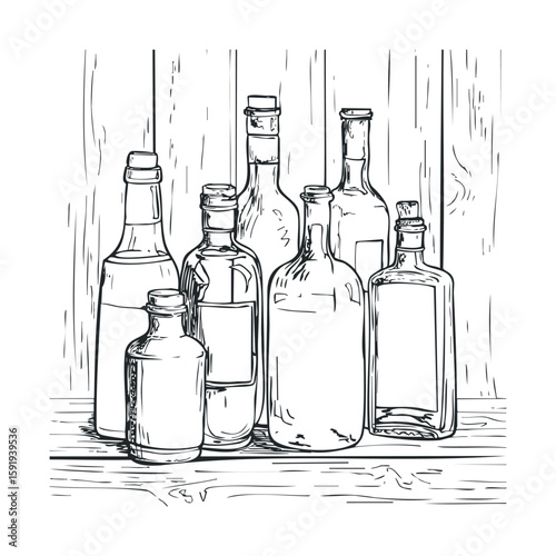 Collection of empty glass bottles on a wooden table for design