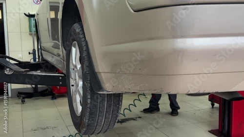 Car repair inspection in auto service workshop, vehicle maintenance process, garage background.