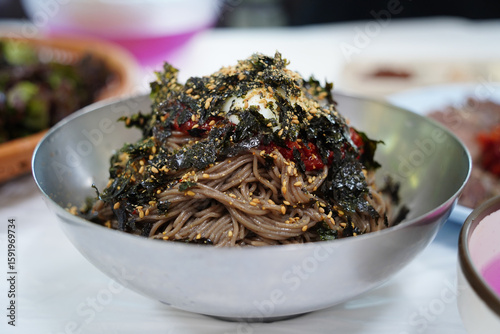 Close-Up of Korean Buckwheat Noodles with Spicy Sauce and Vegetables in Metal Bowl
