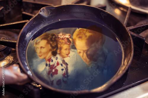 Artistic reflection of vintage family faces inside a tea cup. Surreal, nostalgic and emotional still life – perfect for artistic posters, conceptual photography or wall decor.
