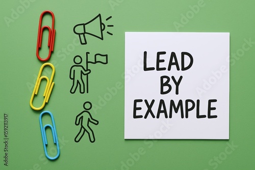 Inspirational and Motivational Quote Lead By Example with Paper Clips and Drawings on Green Background.