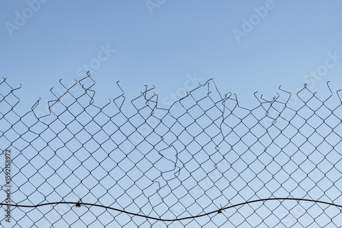 A chain link fence with a broken section