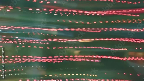 An abstract visual of blurred, flashing lines of red light particles, creating the illusion of rapid movement or flowing data against a dark background.