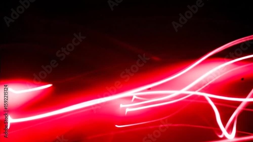 An abstract visual of fast-moving, curved lines of red light creates an intense, dynamic, and futuristic energy effect