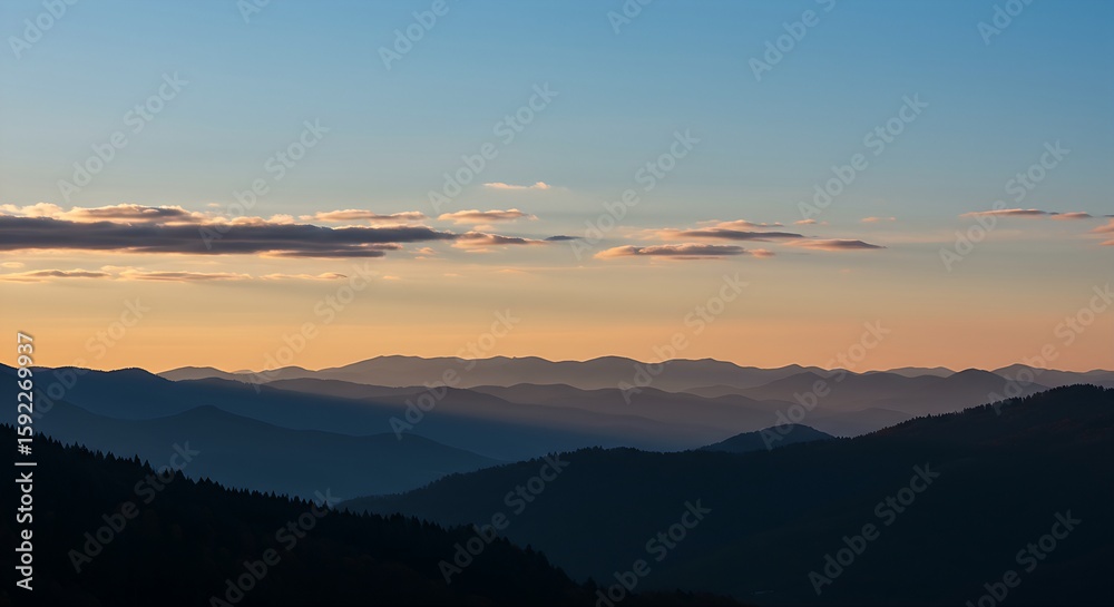 Obraz premium A clear, crisp autumn sky with a few wispy, auspicious clouds, serving as a backdrop for a distant silhouette of multiple mountain peaks