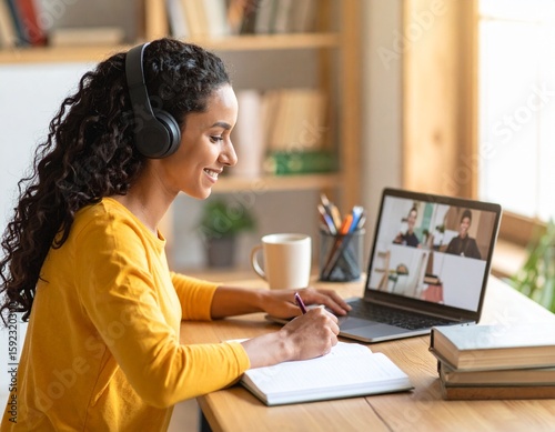 Teen or College Student Attending Online Class with Laptop and Headphones