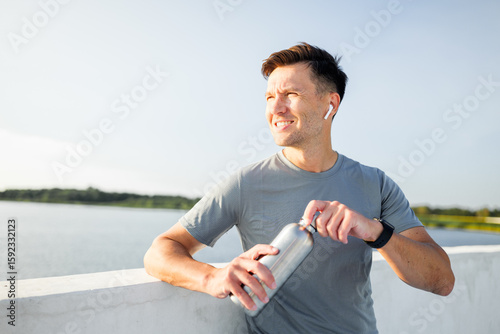 Man enjoys a refreshing moment by the water while staying active and hydrated