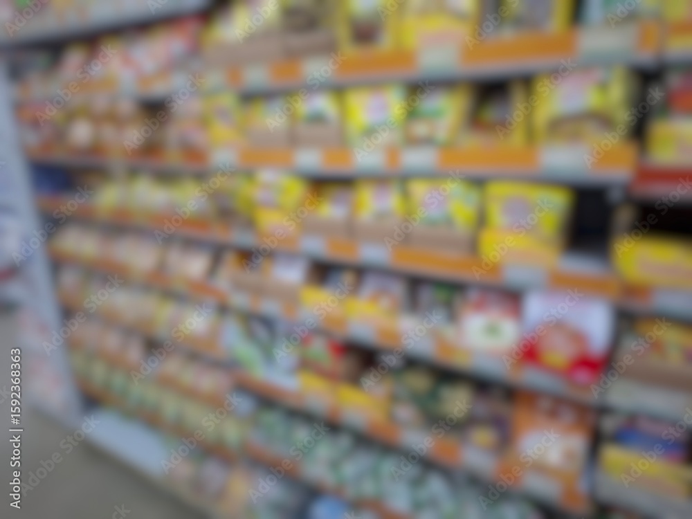 Fototapeta premium Blurry image of a supermarket aisle with shelves full of products. An abstract retail background for business, shopping, supermarket concepts, or consumer markets.