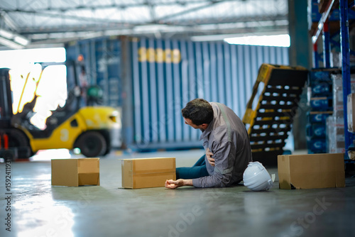 Slika na platnu Workplace injury in logistics sector: elderly man fell among cargo