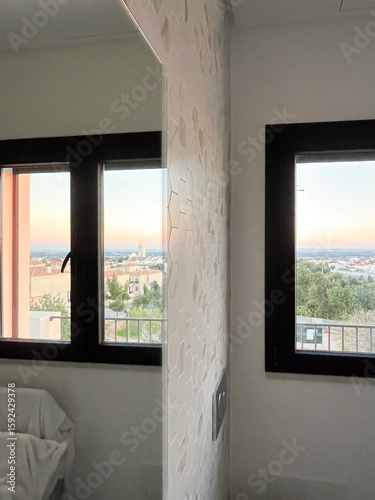 Modern interior design featuring hexagonal tile wall, large windows with scenic view, and soft natural light illuminating the space, creating a serene atmosphere