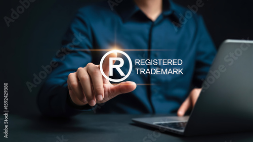 A persons finger touches a glowing registered trademark symbol and text, emphasizing brand protection and intellectual property in the digital age