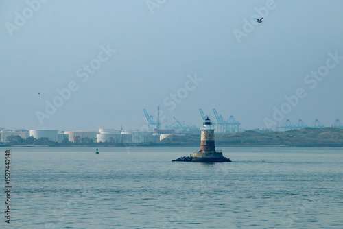 Photos Robbins Reef Lighthouse y al fondo edificios industriales del puerto de New Jersey