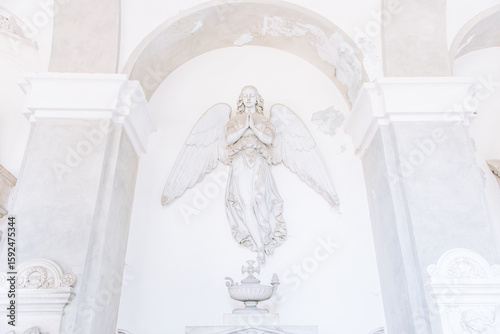 Ancient statue of angel in Italian old cemetery. Religious sculpture, no people, grey marble