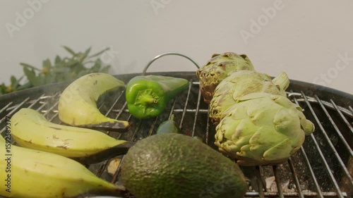 Grilled Banana on fire, latin american vegan grill with avocado and pepper, thai or Ecuadorian Street food. African traditional food on grill. 