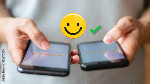 Person holding two smartphones showing star ratings and happy face mobile phone hands