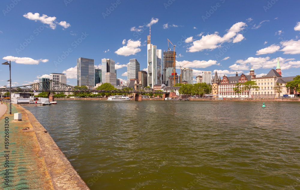 Obraz premium View of the skyline and the Main River with Alte Bruecke bridge in Frankfurt am Main Germany on a clear summer day