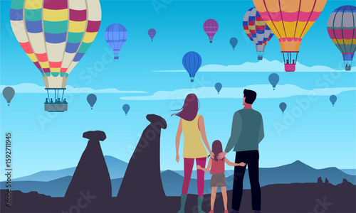 Tourist family looking at balloons at sunrise, Cappadocia.