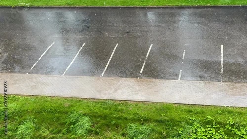 Empty parking lot after summer rain. Wet asphalt reflects light, atmospheric scene.