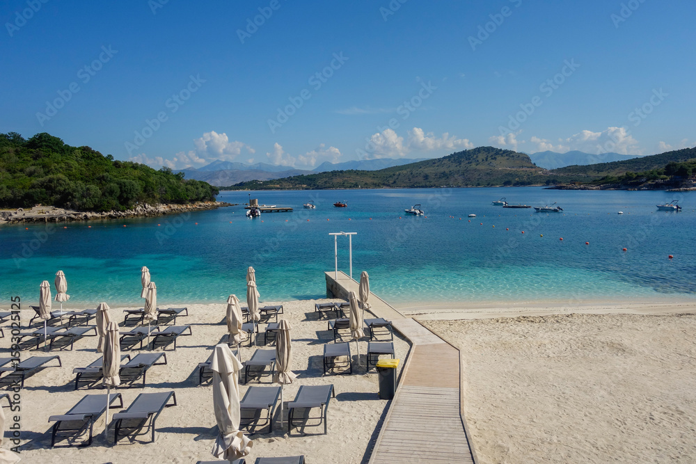 Fototapeta premium beach umbrellas closed during low season on the beach in Ksamil, Albanian rivieira