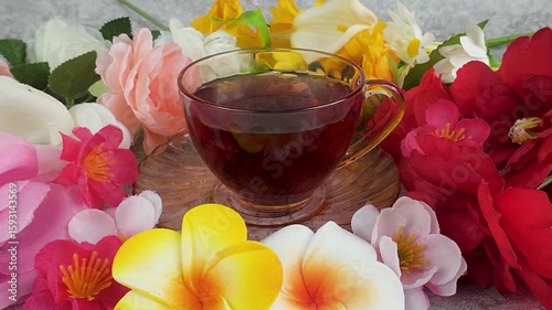 Tea Cup Still Life with Colorful Artificial Flowers on Gray Background