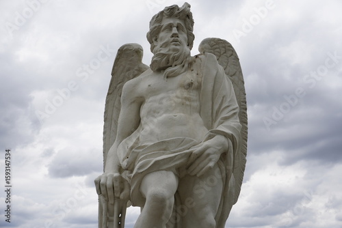 Sandstone statue of the ancient Roman god Saturn, or Saturno, as an angel with mighty wings in the sculpture garden of Herrenhausen Palace, Hannover, Germany