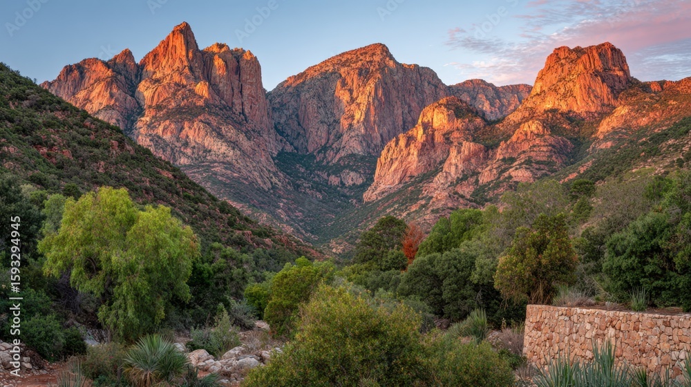 Fototapeta premium Sunrise over mountain range with soft orange light illuminating peaks and valleys