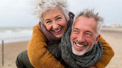 Happy Senior Couple Beach Fun Smiling Joyful Winter Outdoors Romantic Elderly Love Affectionate Relationship Mature Adults Seaside Happiness Grey Hair Cold Weather       