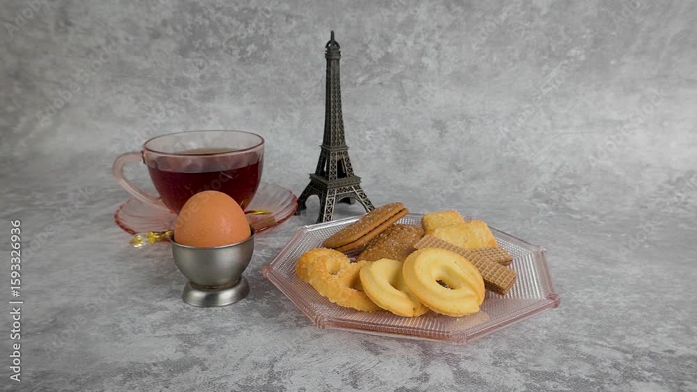 Enjoying Cookies with Tea and an Egg on a Grey Background