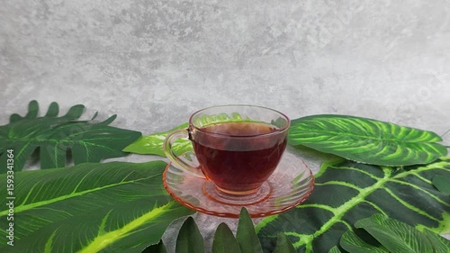 Enjoying Herbal Tea Surrounded by Fresh Green Leaves Relaxation and Wellness