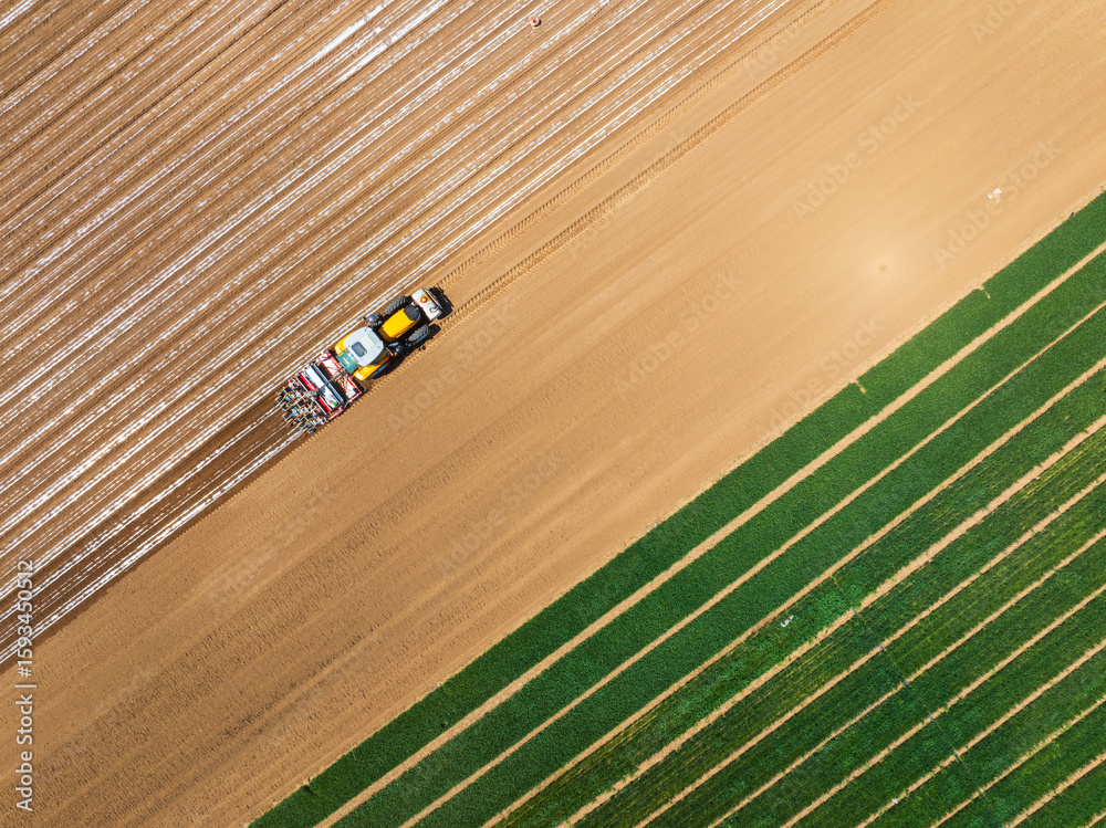 Obraz premium In spring, farmers use farm machinery to grow peanuts,Aerial photos of farmers using agricultural machinery to cultivate the land.