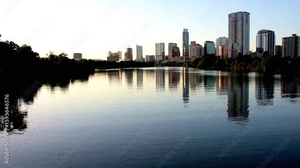 Austin, texas skyline reflects in the colorado river at sunset Austin, texas skyline reflects in the colorado river at sunset