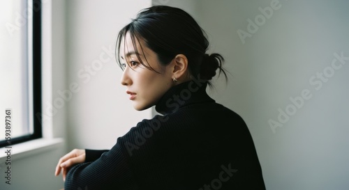 窓辺の黒タートルネック女性のポートレート写真
