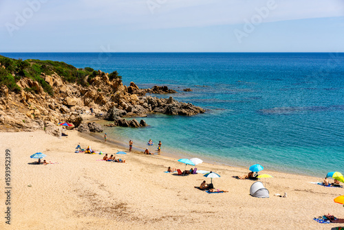 Fototapeta Naklejka Na Ścianę i Meble -  Tourists relaxing on the beach of Portu de S'Ilixi in Sardinia, Italy