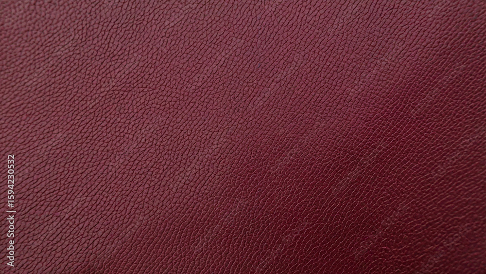 Fototapeta premium Close up of a textured dark crimson red surface with subtle gradient and fine grain detail creating a rich and luxurious background