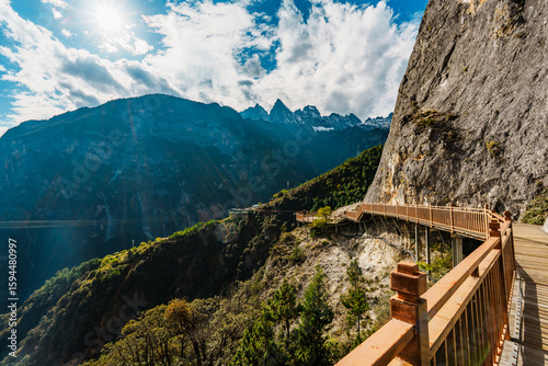 Sunlit mountain walkway overlooking deep gorge in Balagezong, Shangri-La, China