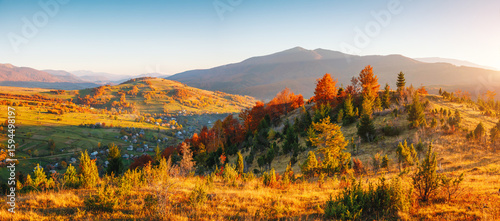 A splendid view of the colorful slopes of distant hills illuminated by the sun's rays. Carpathian mountains, Ukraine, Europe.