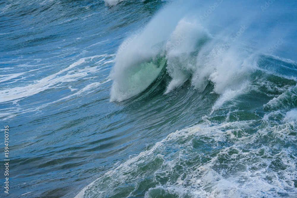 Obraz premium Powerful ocean waves crash along the Hermanus shoreline after a dramatic winter storm, capturing the raw energy and beauty of nature on the Whale Coast, Overberg, Western Cape, South Africa.