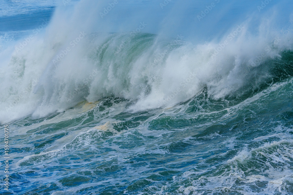 Fototapeta premium Powerful ocean waves crash along the Hermanus shoreline after a dramatic winter storm, capturing the raw energy and beauty of nature on the Whale Coast, Overberg, Western Cape, South Africa.