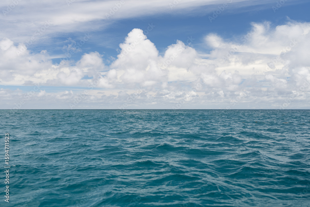 Fototapeta premium Ocean waves with turquoise water and white clouds