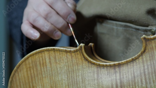 Obraz na plátně Skilled luthier carefully varnishing handcrafted violin, creating vintage aesthe